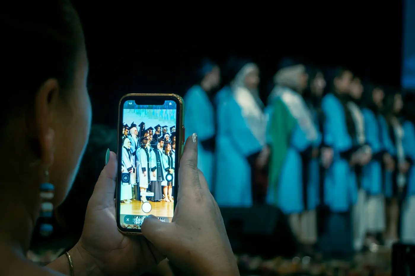 Pessoa filmando a colação de grau com o celular